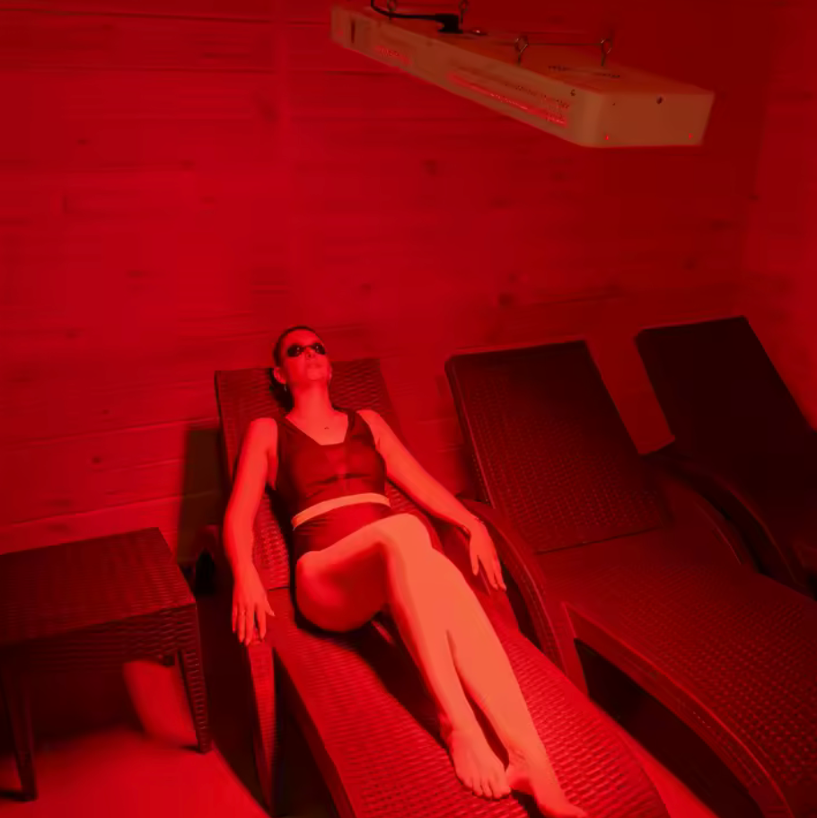Woman standing in front of 850nm near-infrared light therapy panel for deep tissue recovery and cortisol reduction