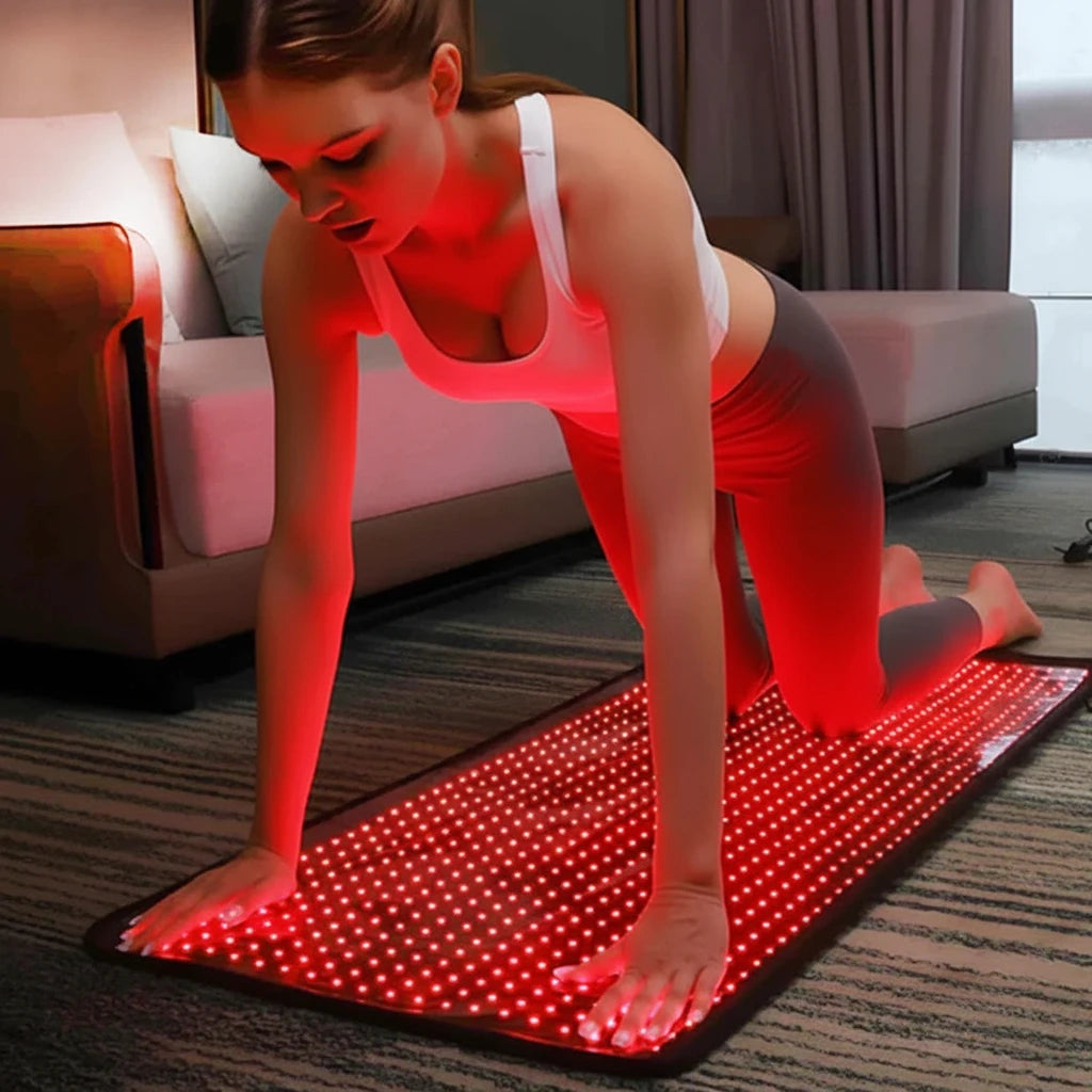 Woman using LumiMat Pro 406 LED red light therapy mat for back recovery