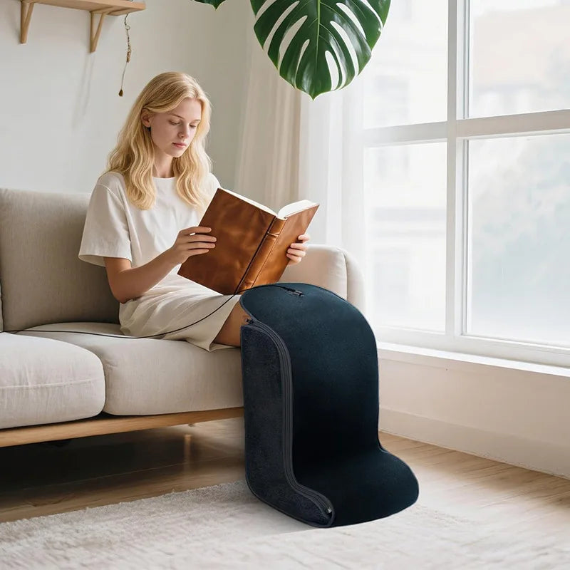 Woman reading on a sofa with her feet inside the ToeGlow Pro red light wrap
